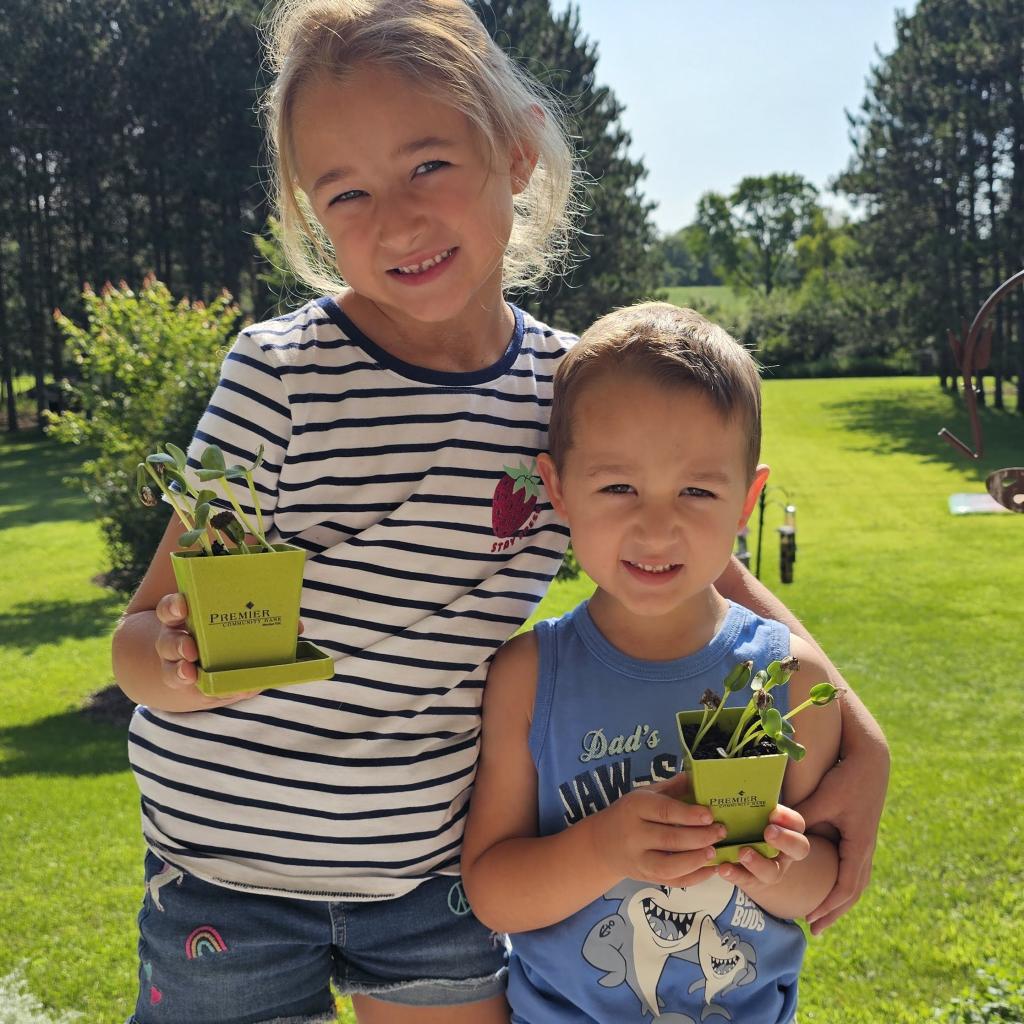 Our Premier Pad members, Erin and Calvin, are shown with their growing sunflowers!